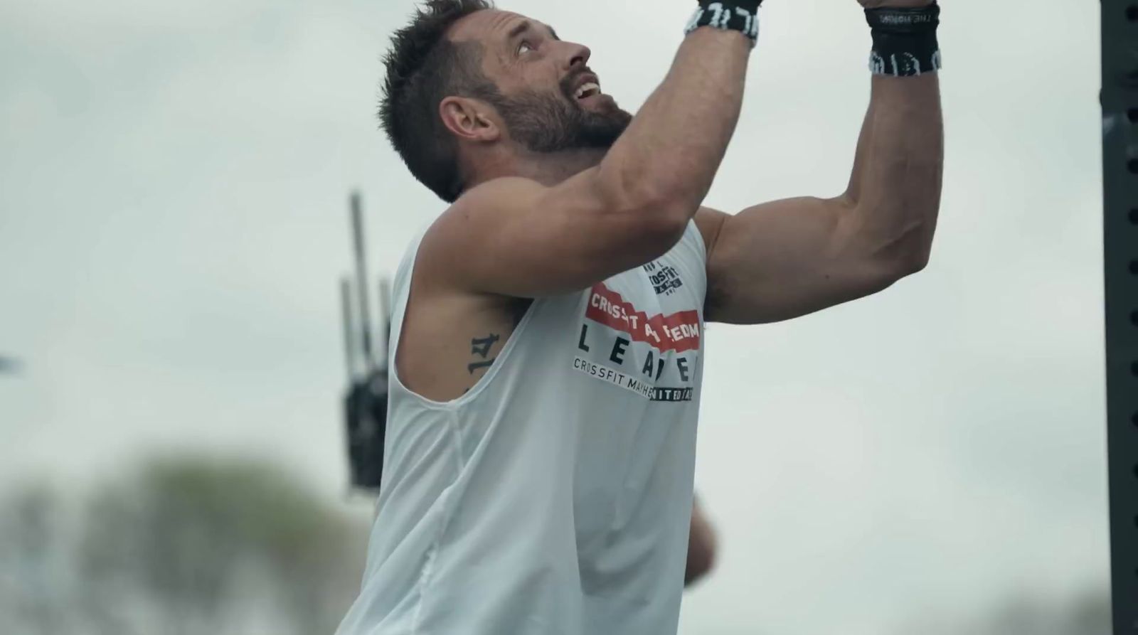 a man holding a barbell in his right hand