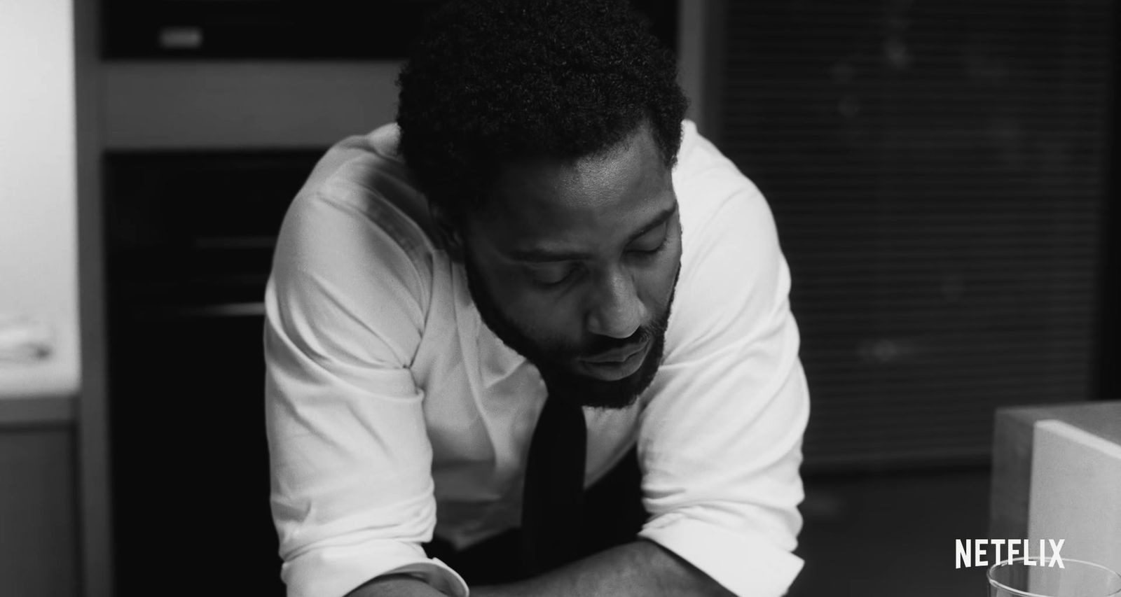 a man in a white shirt and tie writing on a piece of paper