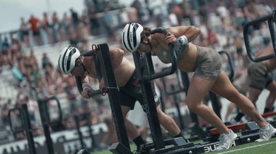 a man and a woman doing squats in front of a crowd