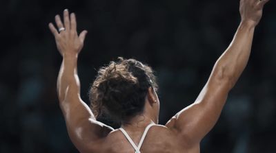 a female tennis player raising her arms in the air