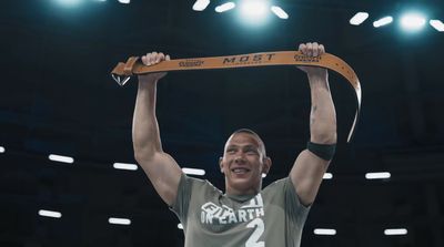 a man holding up a medal in front of a crowd