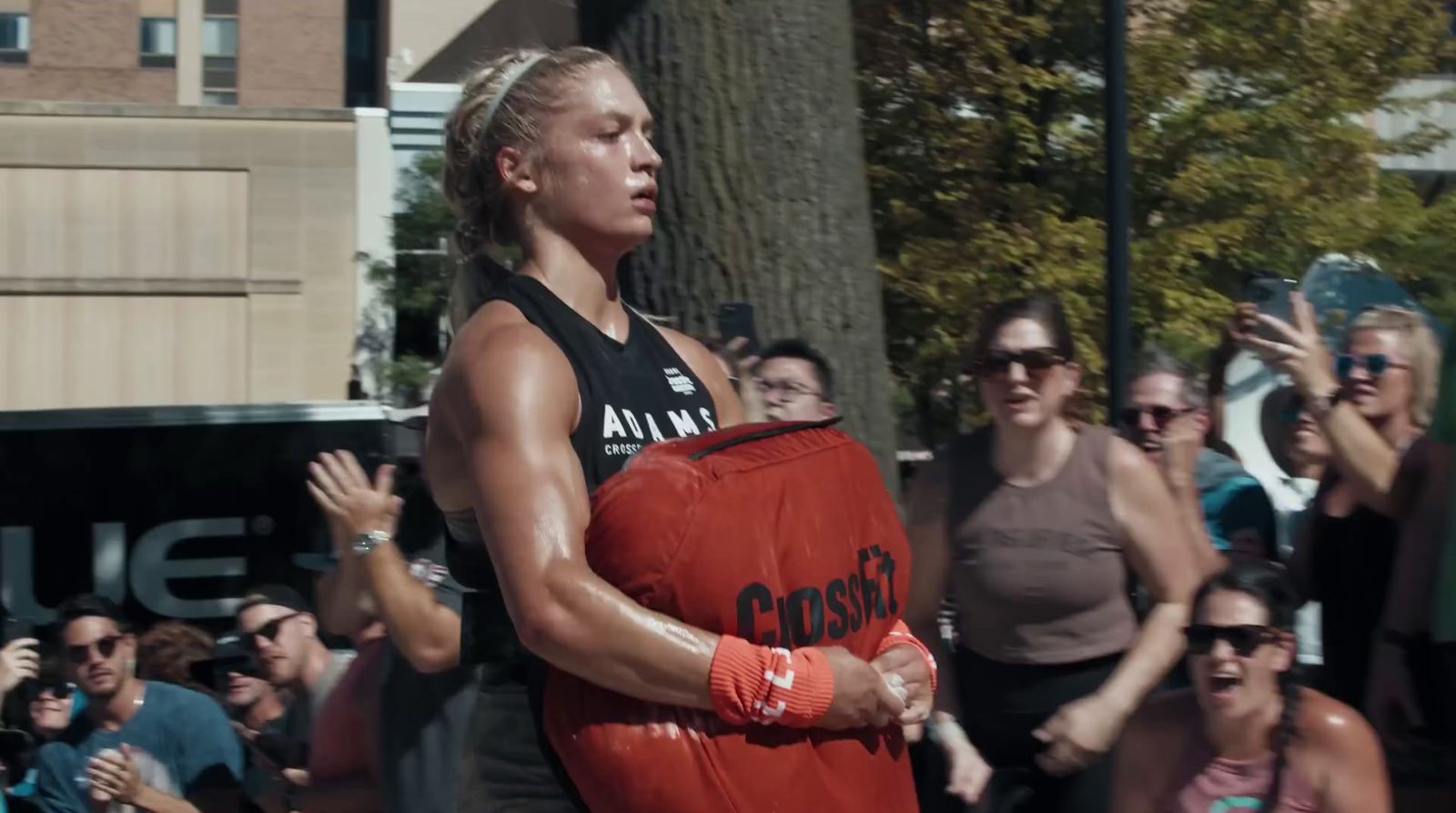 a woman holding a red object in front of a crowd of people