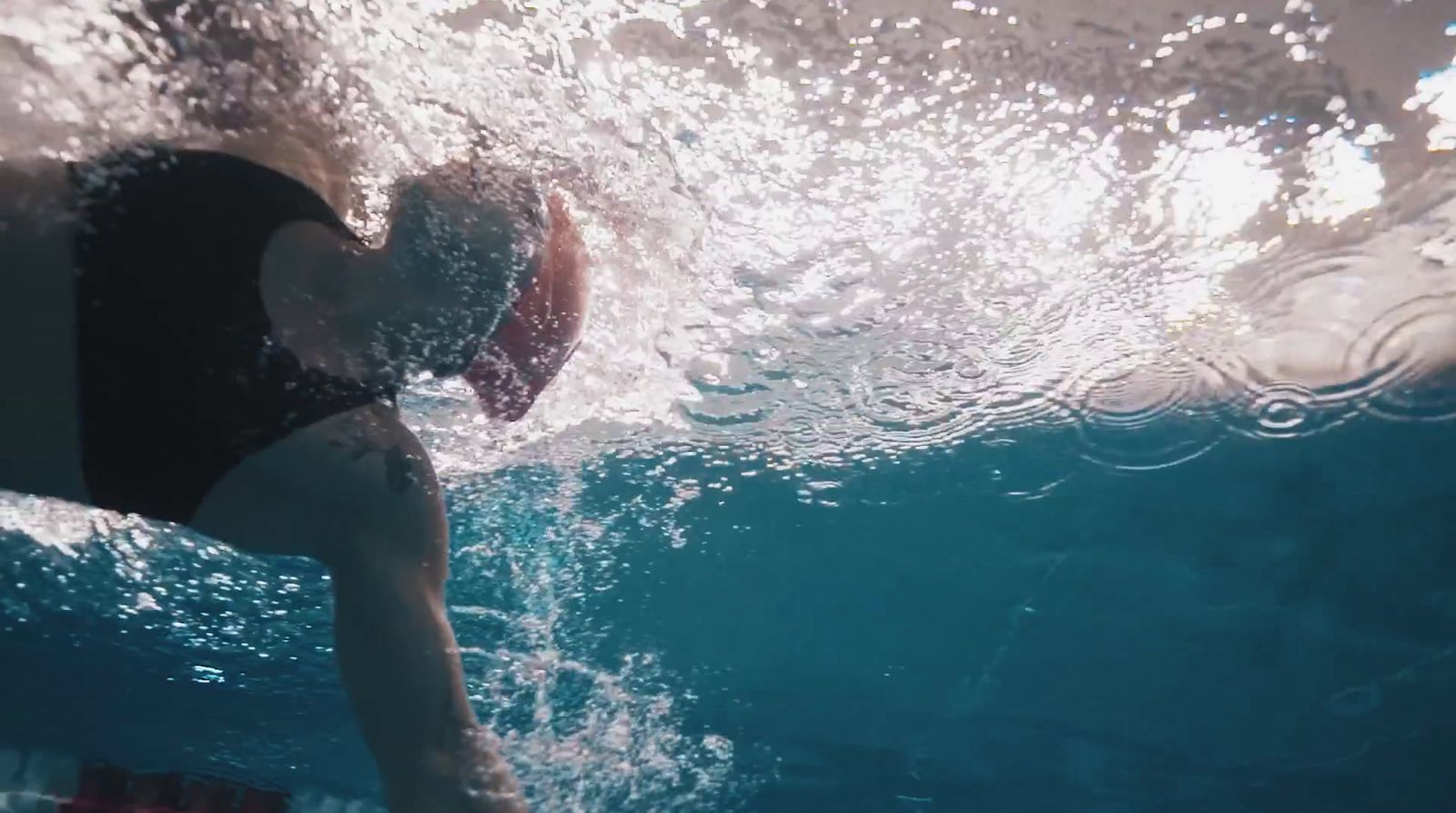 a woman swimming under water in a pool