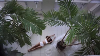 a woman in a white dress laying on a tiled floor