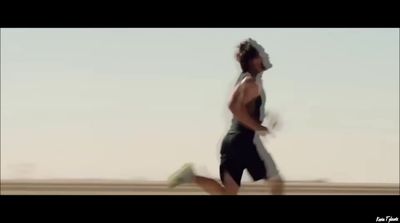 a man running in the desert with no shirt on