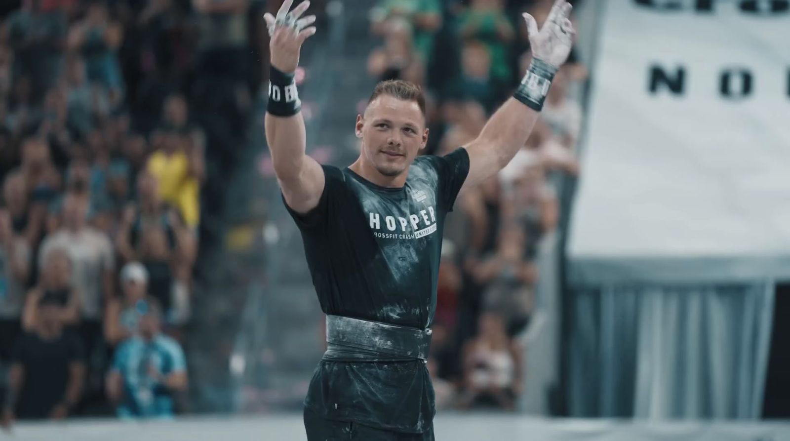 a man in a wrestling ring raising his hands in the air