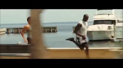 two men are running on a dock near a boat