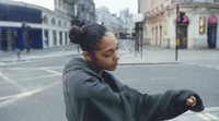 a woman standing on the side of a road