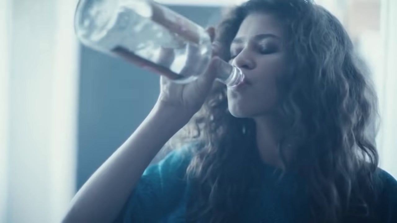 a woman drinking from a bottle of water