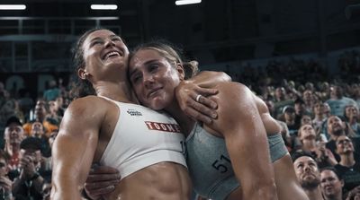 two women hugging each other in front of a crowd