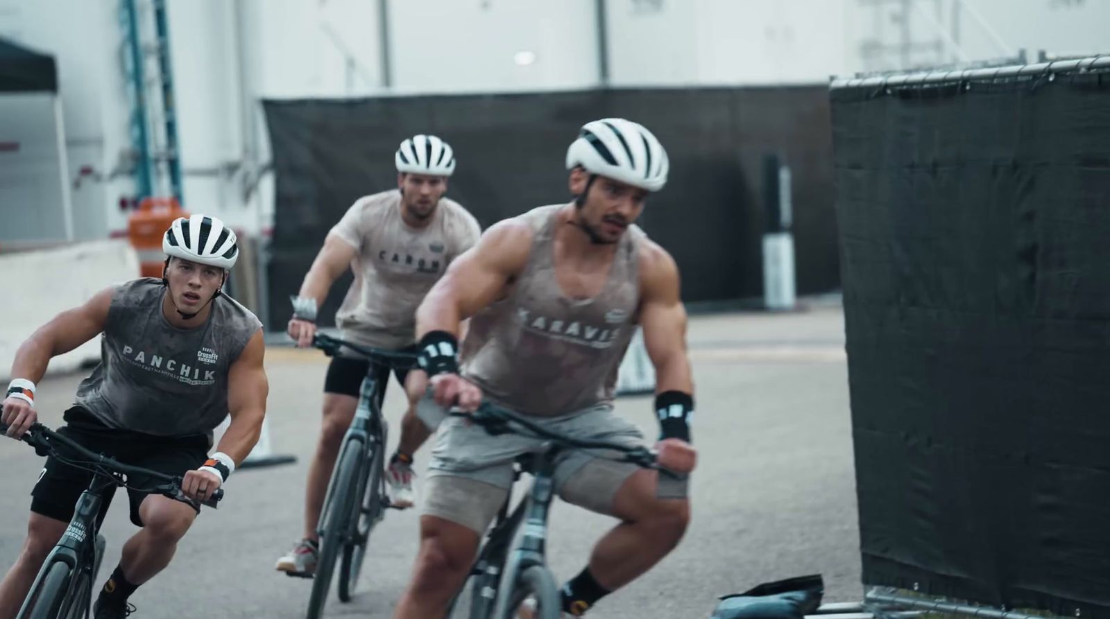 a group of men riding bikes down a street