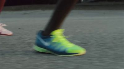 a close up of a person's foot with a yellow and blue shoe