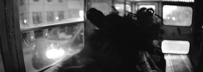 a black and white photo of a dog looking out a window