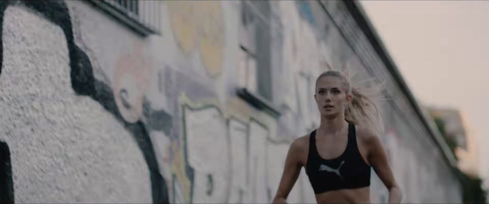 a woman in a black sports bra running down a street