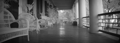 a row of white wicker chairs sitting on top of a wooden floor