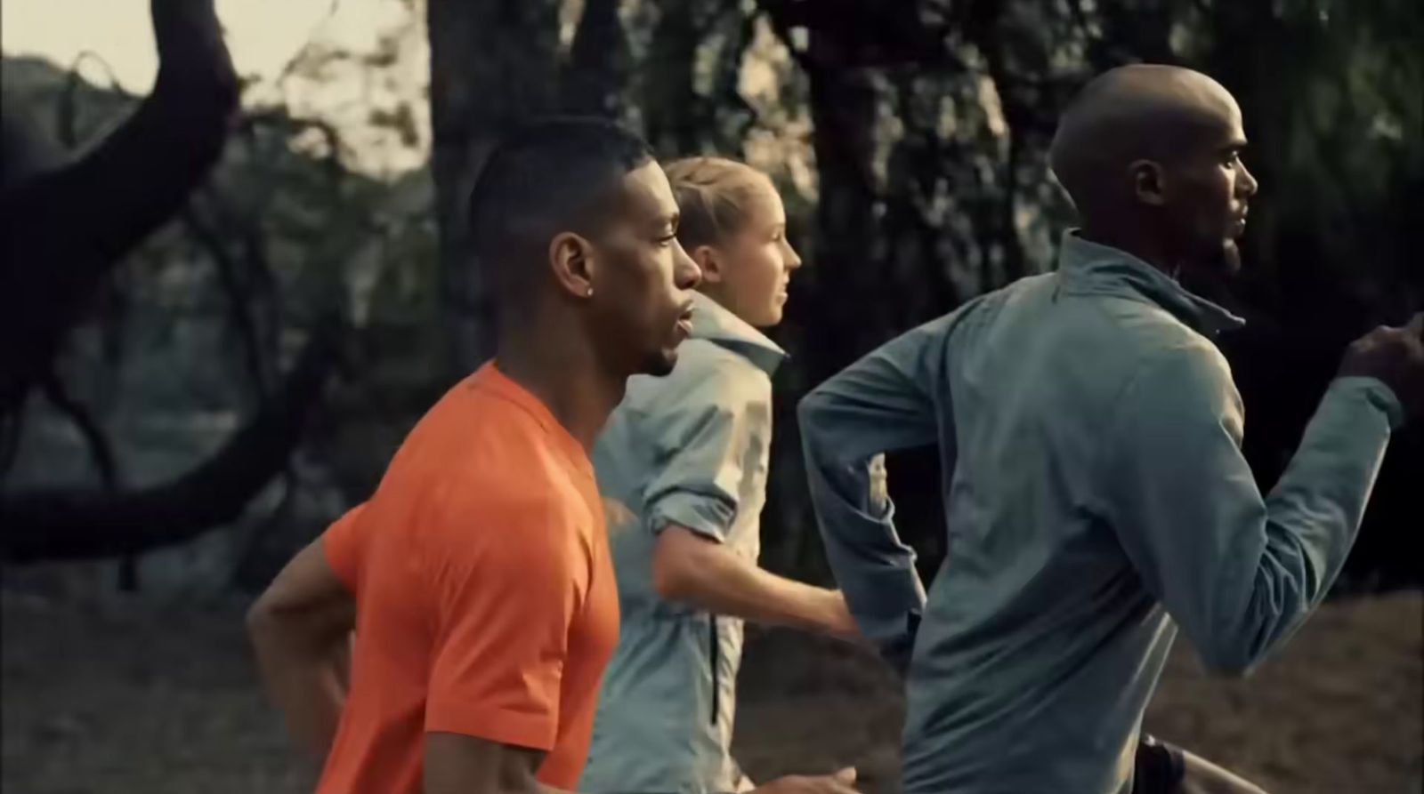 a group of men running through a forest