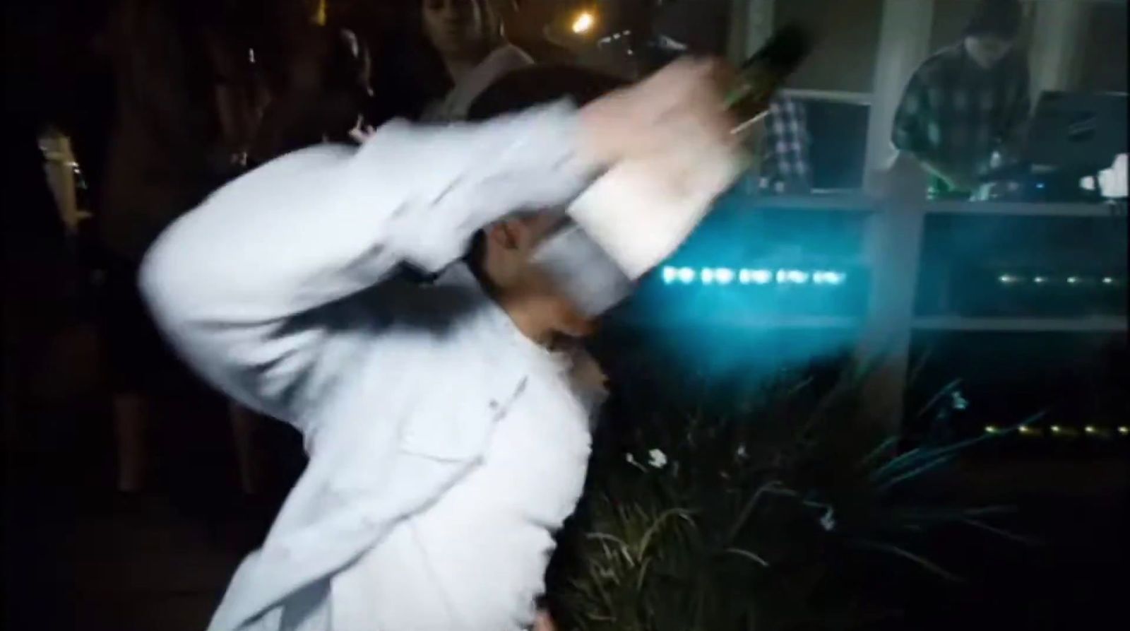 a man in a white suit is dancing