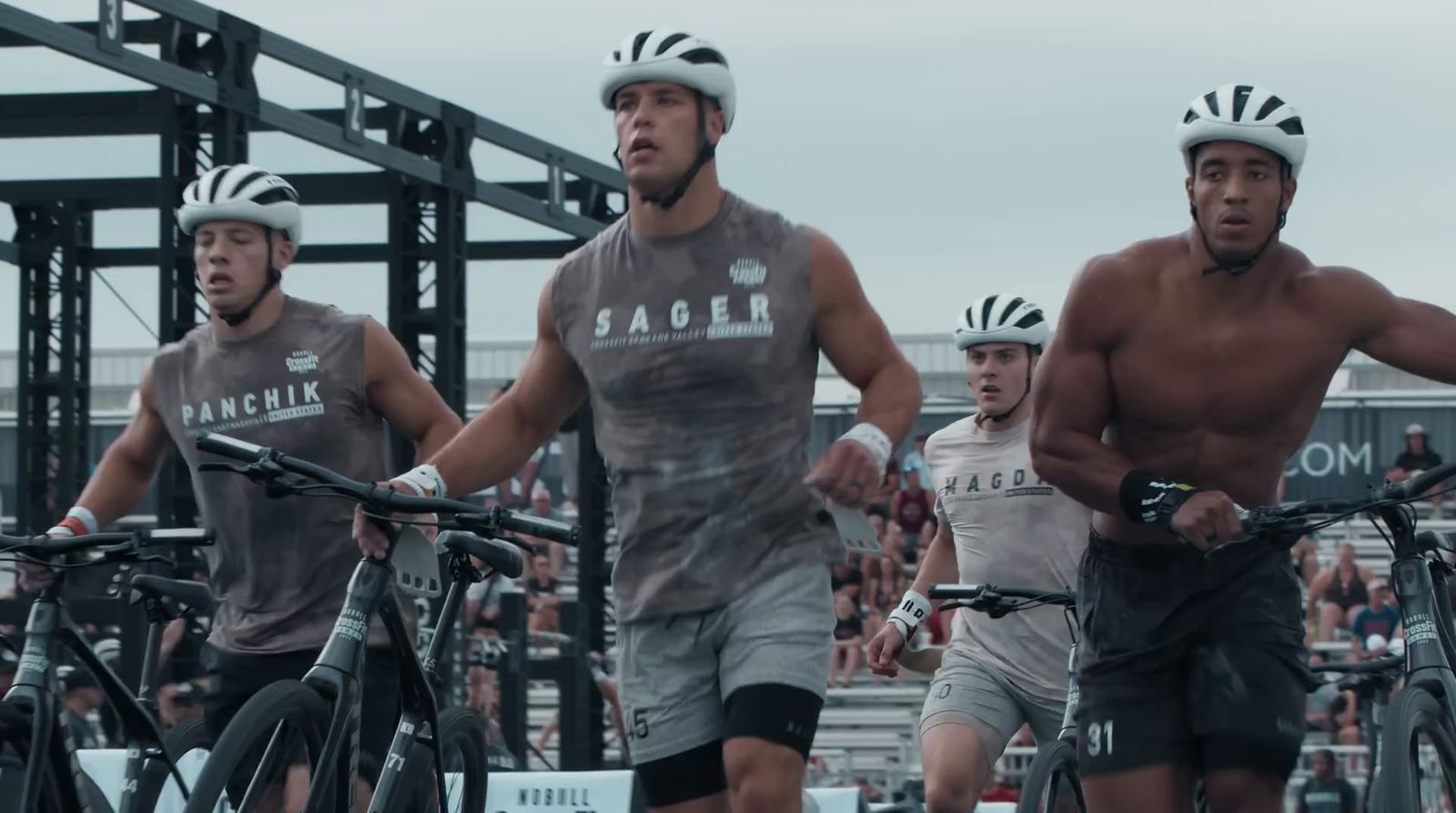 a group of men riding bikes down a street