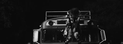 a man standing on top of a bus at night