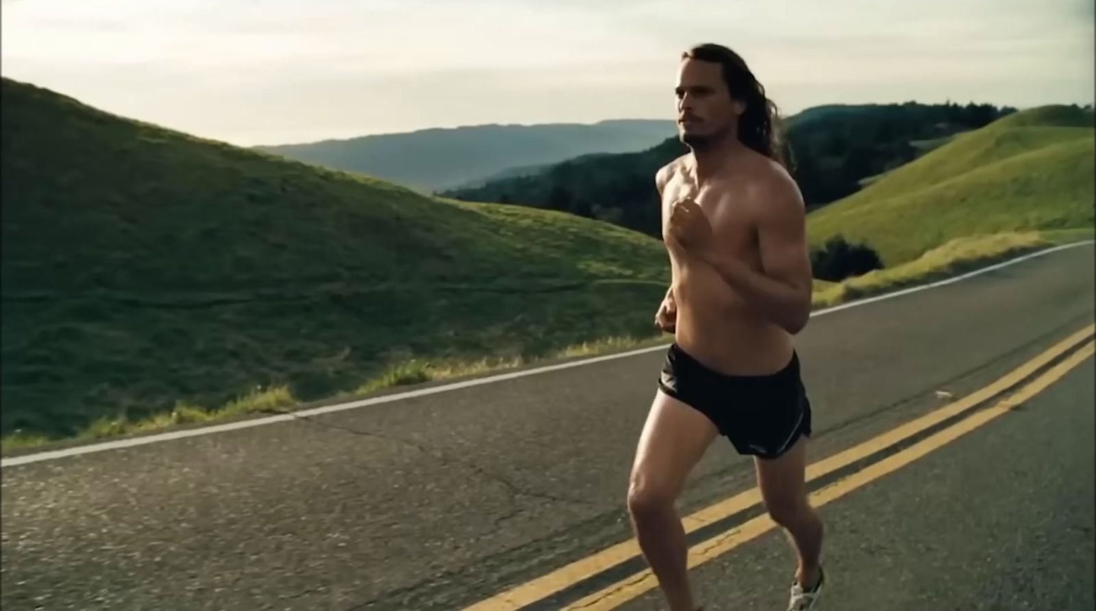 a shirtless man is running down the road