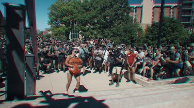 a woman holding a basketball in front of a crowd of people