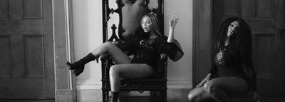 a black and white photo of two women sitting on a chair