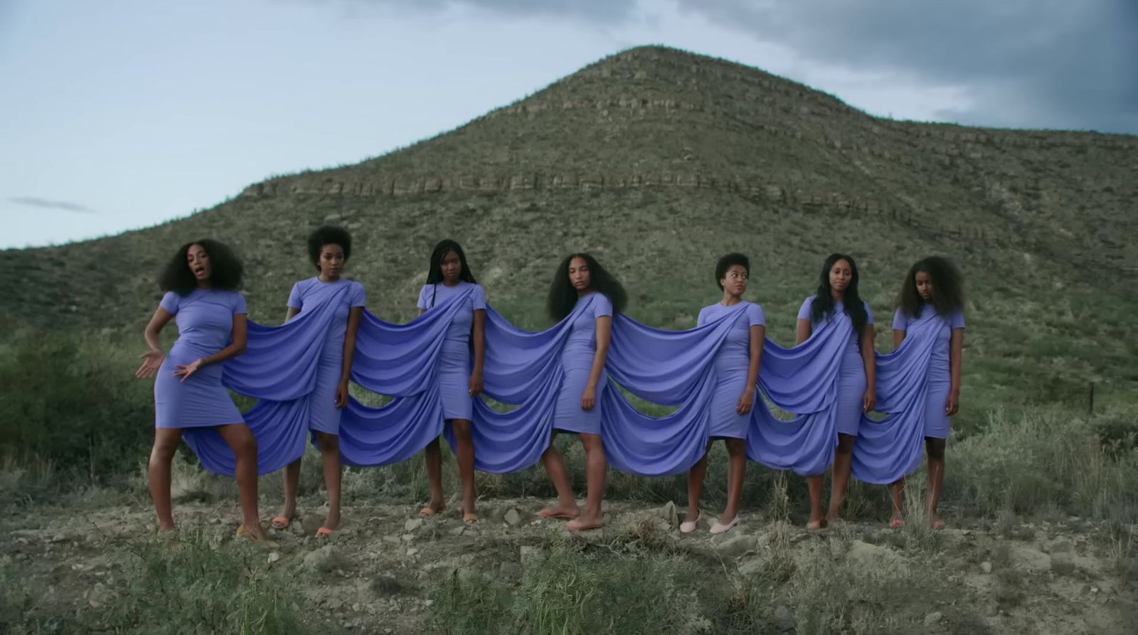 a group of women standing in front of a mountain