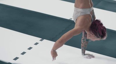 a woman doing a handstand on a white floor