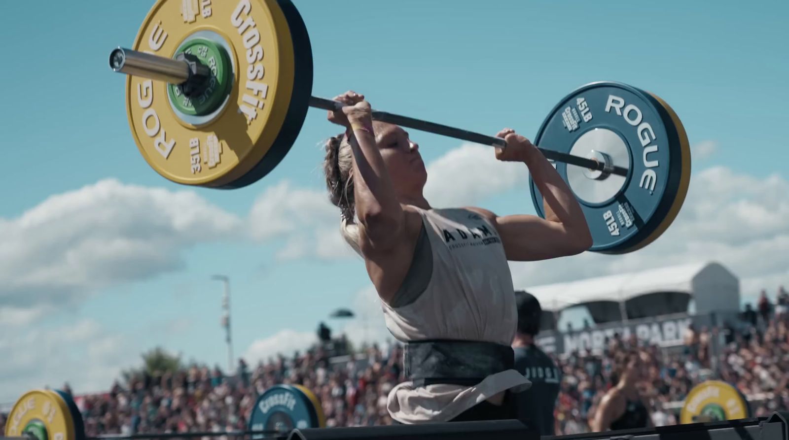 a man holding a barbell in front of a crowd