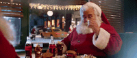 a man dressed as santa clause sitting at a table