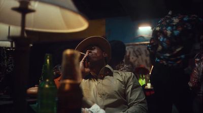 a man in a hat smoking a cigarette