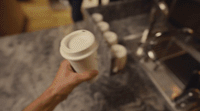 a person holding a cup of coffee in their hand