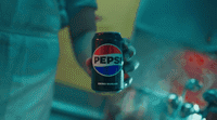 a person holding a can of pepsi in their hand