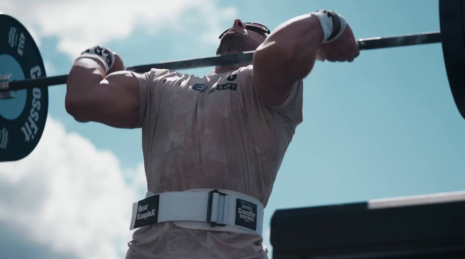 a man holding a barbell in front of his face