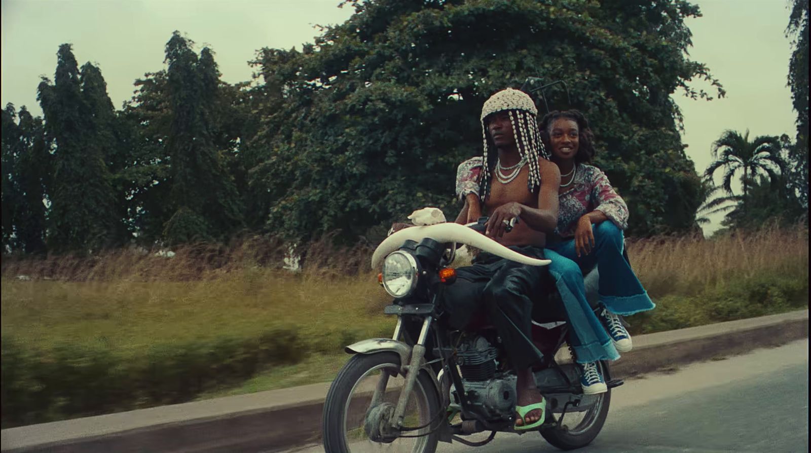 a couple of people riding on the back of a motorcycle