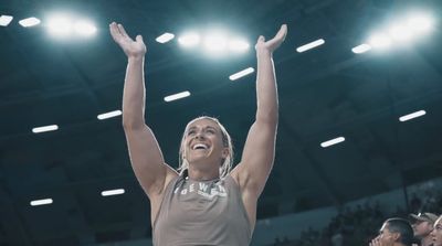 a female basketball player raising her arms in the air