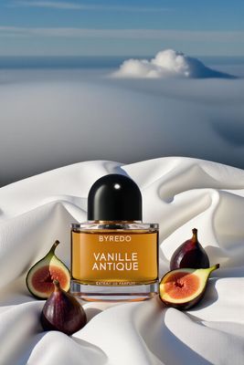 a bottle of perfume sitting on top of a white sheet
