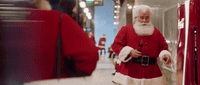 a man dressed as santa claus walking down a hallway