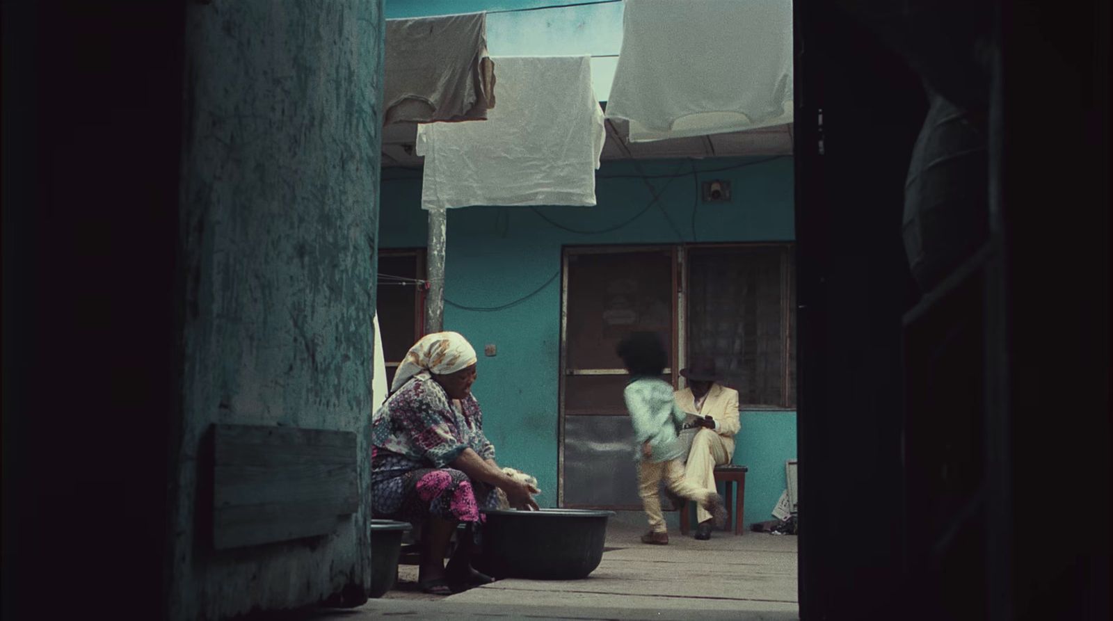 a woman sitting on a bench next to a building