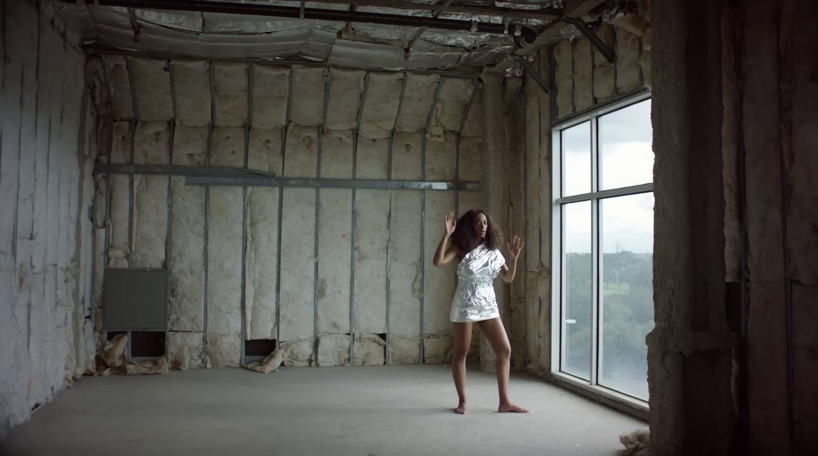 a woman standing in a room next to a window