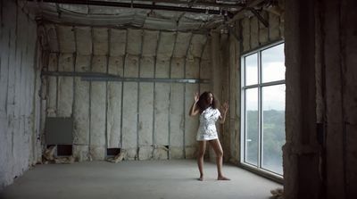 a woman standing in a room next to a window