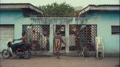 a man riding a motorcycle next to a blue building