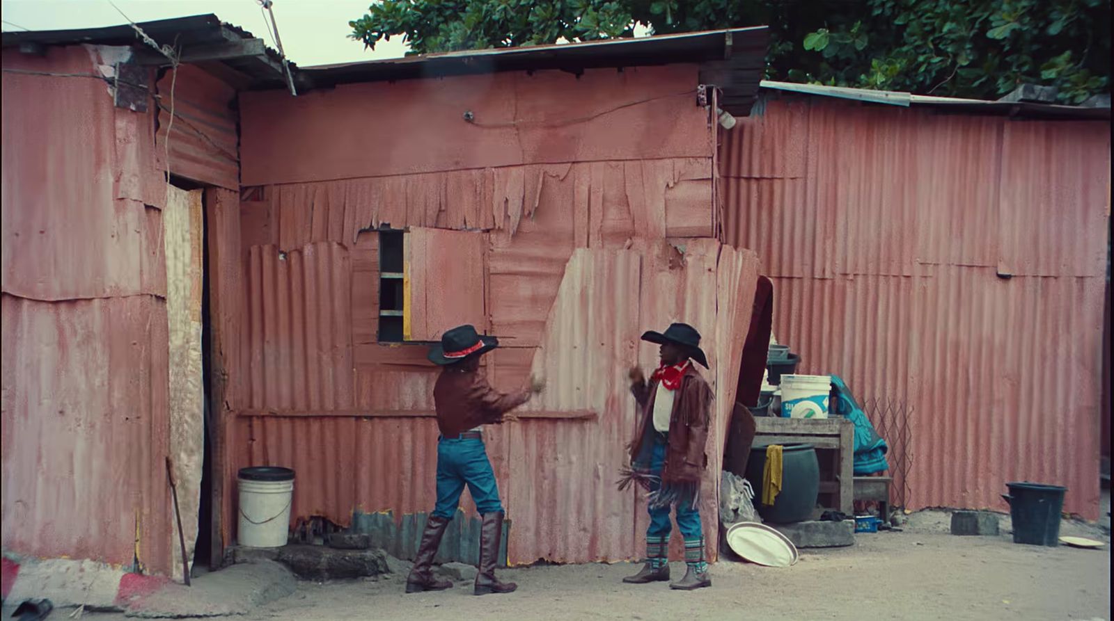 a couple of men standing next to a pink building