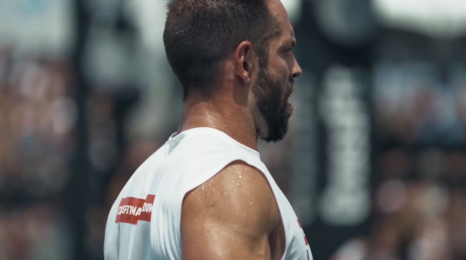 a close up of a man with a beard wearing a tank top