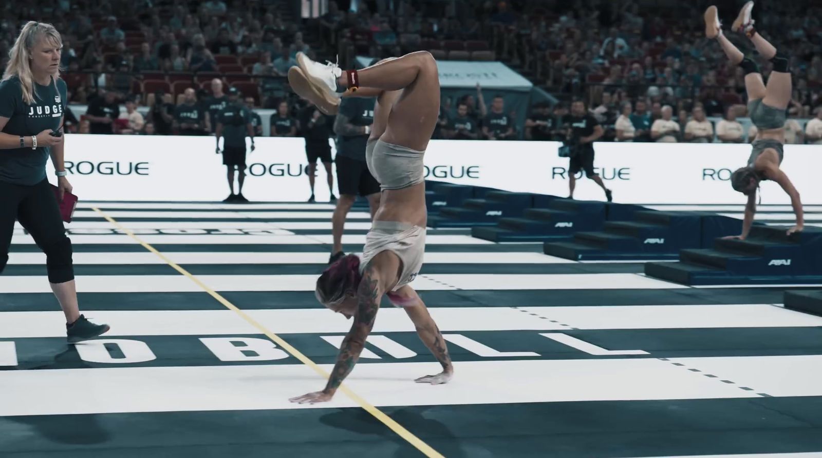 a man doing a handstand on a wrestling ring