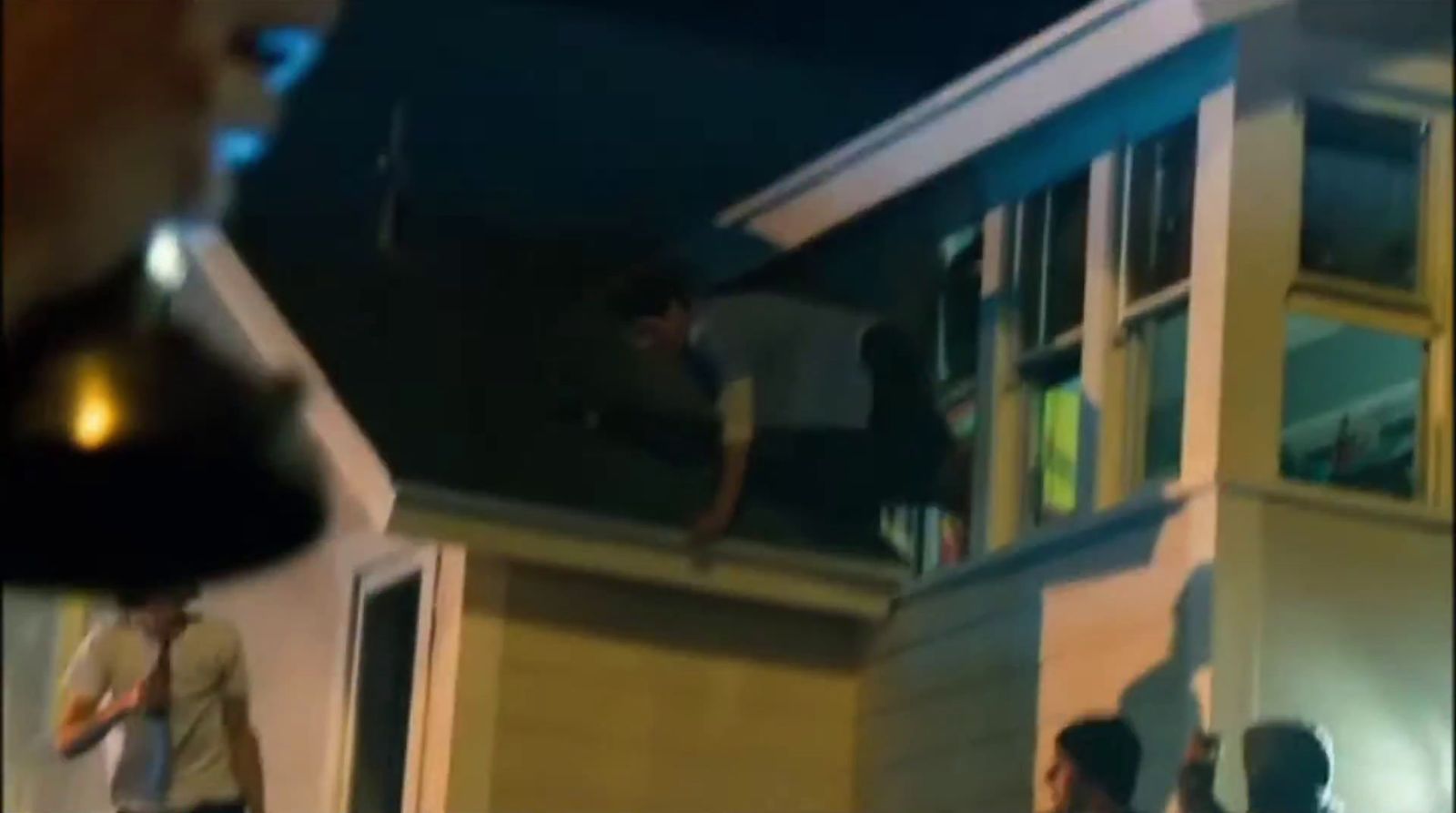 a group of people standing outside of a house at night