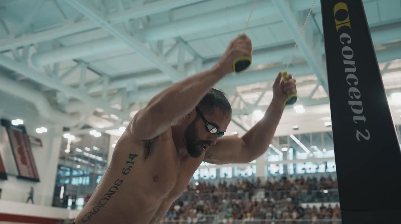 a shirtless man holding a ball in a gym