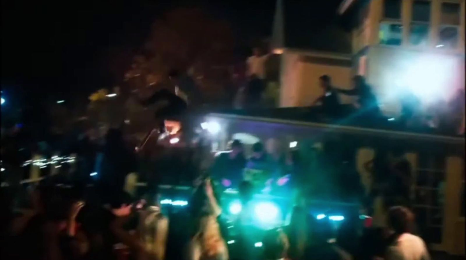 a crowd of people standing around a train at night