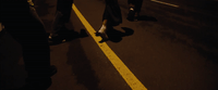 a group of people walking down a street at night