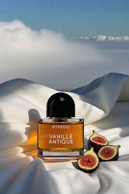 a bottle of perfume sitting on top of a bed
